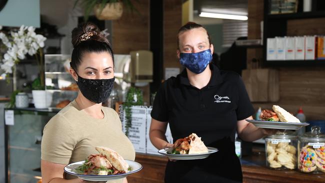 Ozmosis owner Lauren Vico and staff member Rennae Roy have taken to wearing colourful and sequined masks to brighten up their customer's days. Picture: Brendan Radke