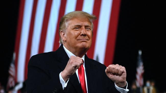 President Donald Trump holds up his fists at the end of a rally in Georgia.