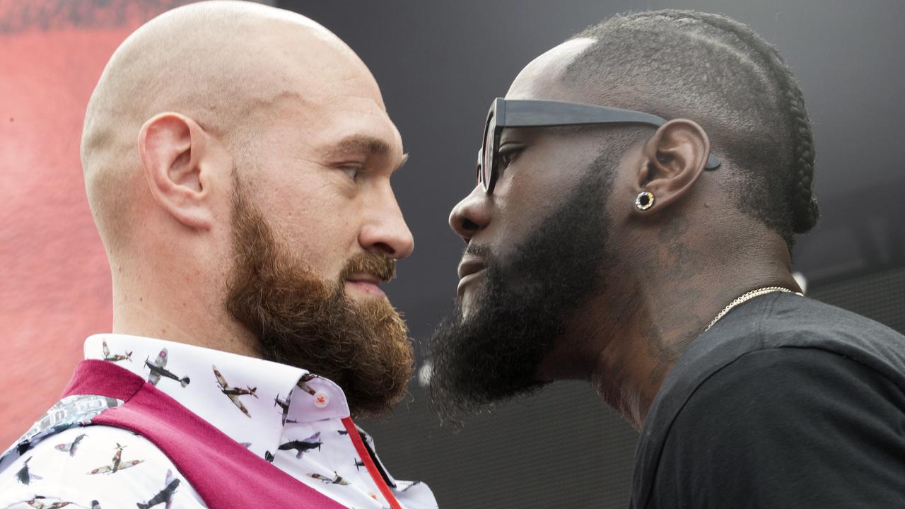 Tyson Fury, left, and Deontay Wilder face off during a news conference.