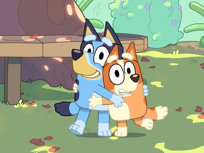 Sisters Bluey and Bingo hug on an episode of the Brisbane-created and based animated series about a family of blue and red heelers. Picture: Supplied