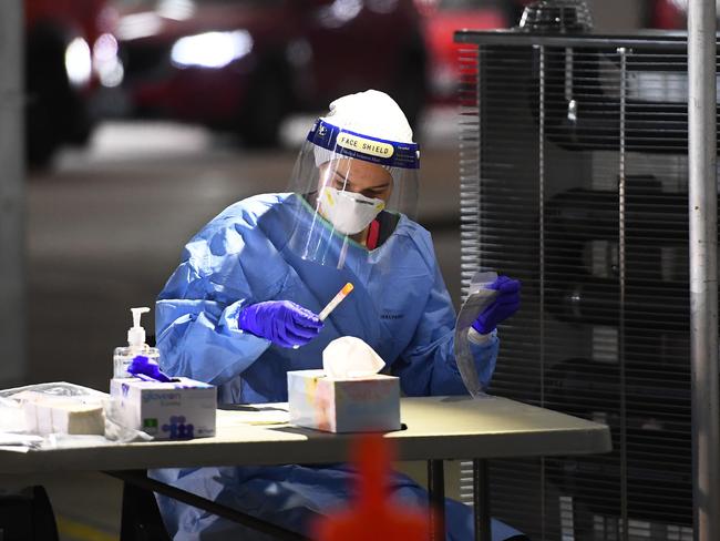 Medical staff take down details after performing tests for the COVID-19 coronavirus on people who used a drive-through testing site in a Melbourne carpark on May 1, 2020. - Australia will consider early easing of coronavirus restrictions next week, officials announced on May 1 as the number of local cases dwindled and the economic impact of the crisis fell into painful relief. (Photo by William WEST / AFP)