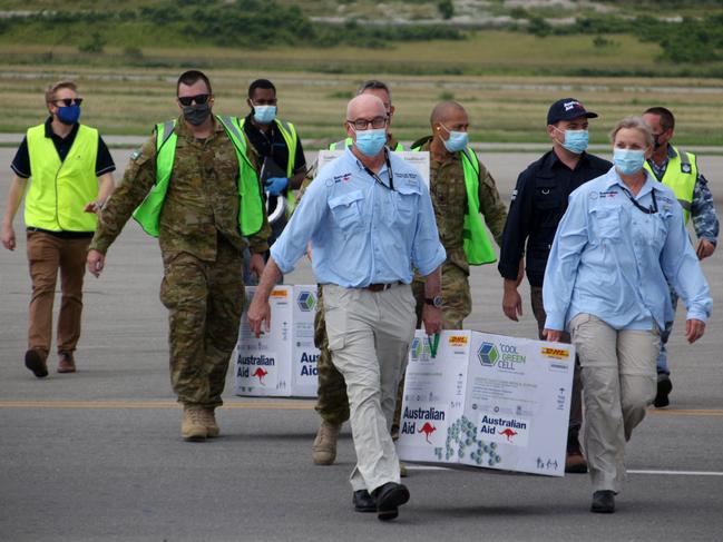 Australian officials carry boxes containing 8500 initial doses of the AstraZeneca vaccine at the Port Moresby international airport on Tuesday. Picture: AFP