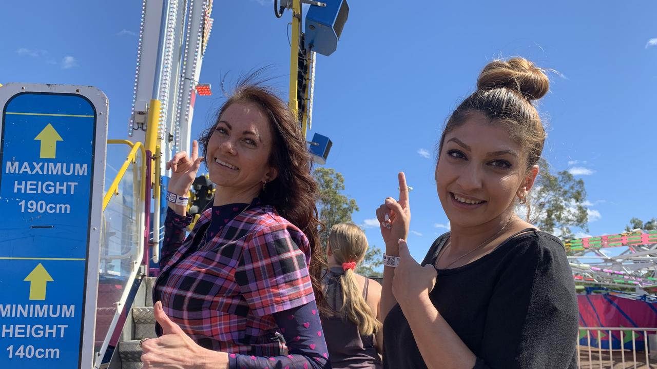 (L) Chantelle Whitehead and Claudia Ramzy point up at the Speed Two ride they went on at the Fraser Coast Ag Show.