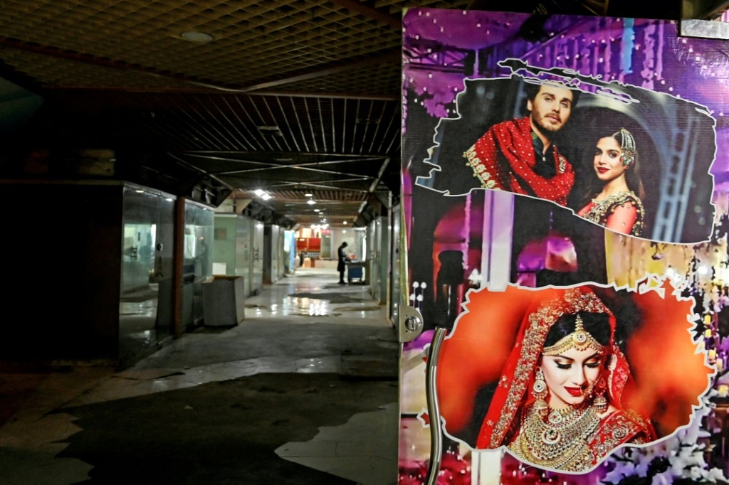 Wedding pictures are displayed outside a marriage bureau office in Pakistan, where apps are beginning to cut into the market occupied by traditional matchmakers