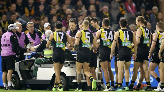 Richmond players get around Reece Conca after he seriously injured an ankle in Round 15. Pic: Michael Klein