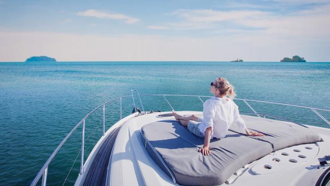 beautiful woman enjoying luxurious yacht cruise, sea travel by luxury boat; rich lifestyle wealth generic