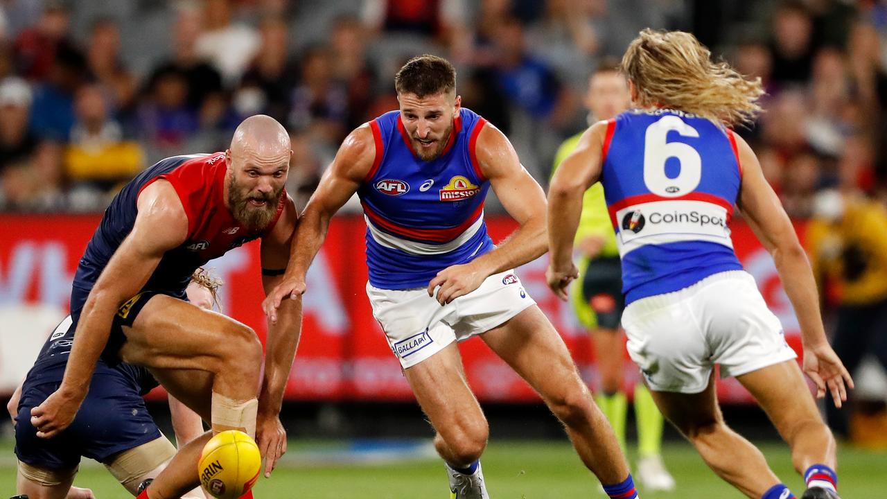 MELBOURNE, AUSTRALIA - MARCH 16: Max Gawn of the Demons and Marcus Bontempelli of the Bulldogs compete for the ball during the 2022 AFL Round 01 match between the Melbourne Demons and the Western Bulldogs at the Melbourne Cricket Ground on March 16, 2022 In Melbourne, Australia. (Photo by Dylan Burns/AFL Photos via Getty Images)