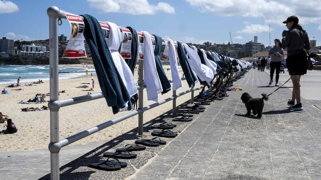 An installation of beach towels and thongs alongside posters showing those kidnapped by Hamas. Picture: NCA NewsWire / Monique Harmer