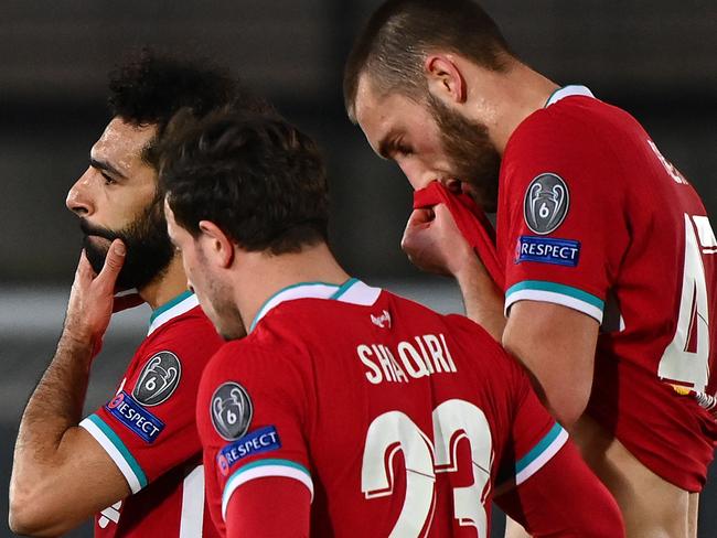 (L-R) Liverpool's Egyptian midfielder Mohamed Salah, Liverpool's Swiss midfielder Xherdan Shaqiri and Liverpool's English defender Nathaniel Phillips react at the end of the UEFA Champions League first leg quarter-final football match between Real Madrid and Liverpool at the Alfredo di Stefano stadium in Valdebebas in the outskirts of Madrid on April 6, 2021. (Photo by GABRIEL BOUYS / AFP)