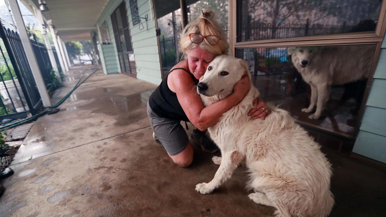 Freda Louizos hugs her dog JoJo after the 11 month old girl returned home after fleeing the fire. Picture: Gary Ramage