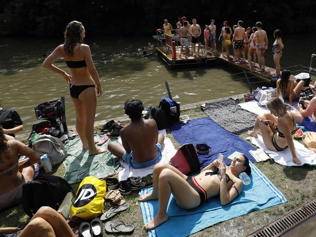 Bathers relax on the perimeter of the mixed-pond on Hampstead Heath in London. Picture: Tolga Akmen