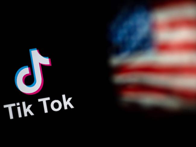 This photo illustration taken on September 14, 2020 shows the logo of the social network application TikTok (L) and a US flag (R) shown on the screens of two laptops in Beijing. - US tech giant Microsoft said on September 13 its offer to buy TikTok was rejected, leaving Oracle as the sole remaining bidder ahead of the imminent deadline for the Chinese-owned video app to sell or shut down its US operations. (Photo by NICOLAS ASFOURI / AFP)