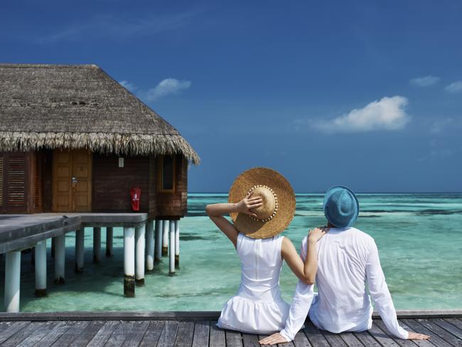 Couple on a tropical beach jetty at Maldives