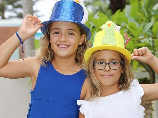 Taylor, 9 (blue dress), and Halle, 7, Krieger, are taking part in a 'Bonnets in the Bunker' virtual Easter bonnet parade with some school friends. Pictured getting ready for their hat parade at home. Picture Rohan Kelly