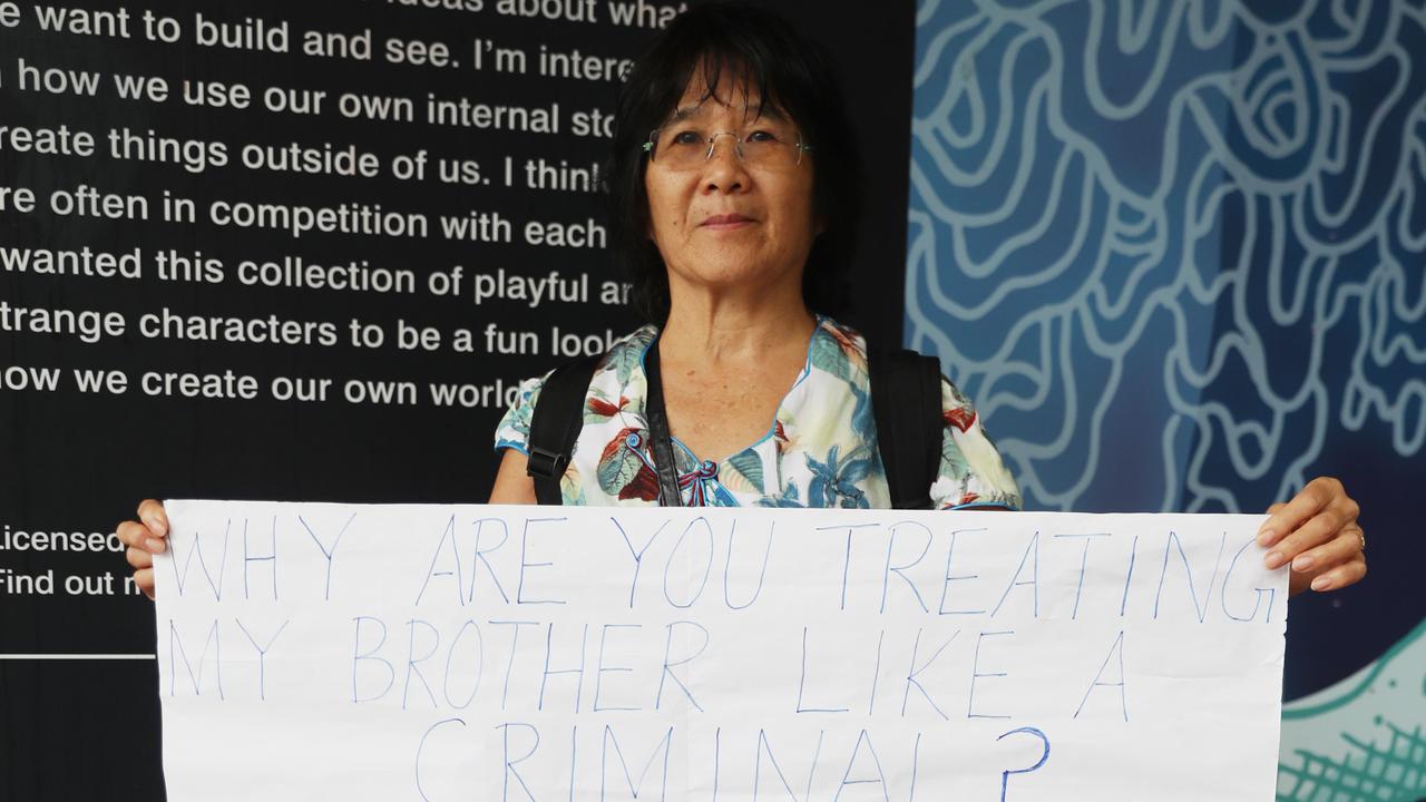 Annie Teo holds up a sign supporting her brother Charlie Teo at the HCCC hearing. Picture: John Grainger