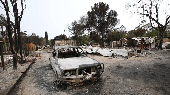 A burnt-out car and home in Mallacoota. Picture: David Caird