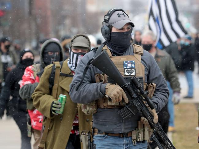 Armed pro-Trump demonstrators walk outside the Michigan state capital building in Lansing, Michigan. Picture: AFP