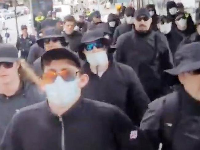 National Socialist Network group marches through Brisbane CBD surrounded by police.