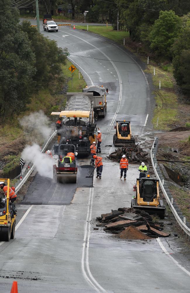 Workmen work quickly to repair a wash-out on Maudsland Rd, Maudsland on Friday. Picture: Glenn Hampson.