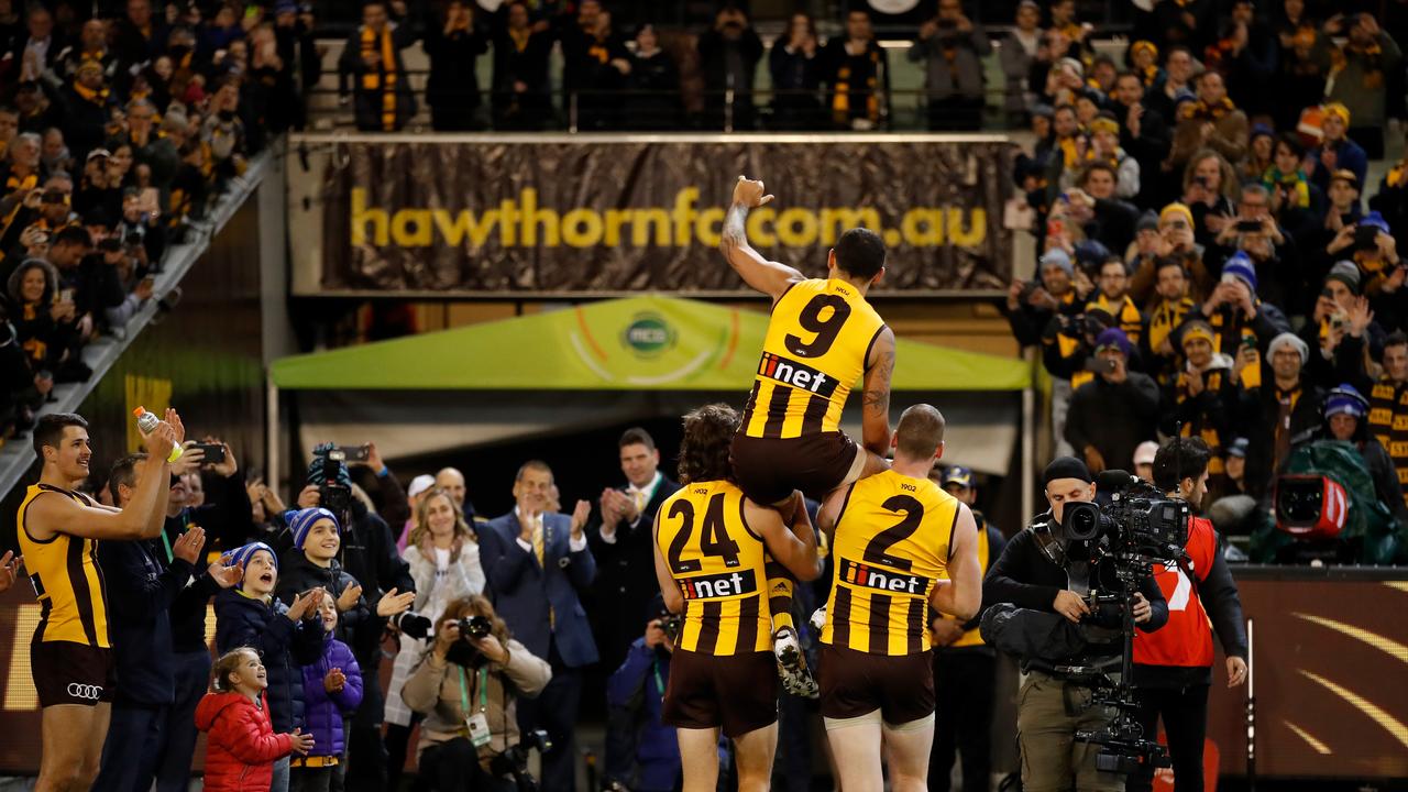 Shaun Burgoyne is carried off by Ben Stratton and Jarryd Roughead in his 350th.