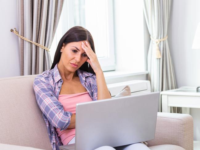 Young frustrated woman working from home in front of laptop ; confused investor generic.