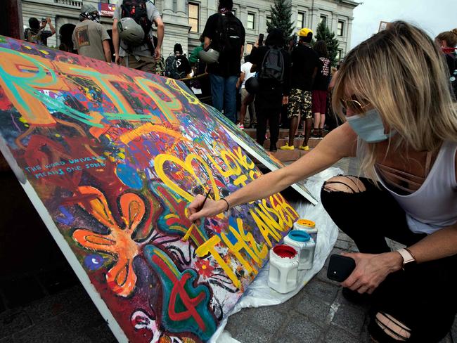 Rachel Douglass adds to a communal painting in Denver, Colorado while protesting the death of George Floyd. Picture: AFP