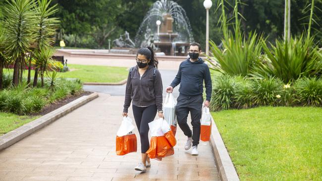 Shoppers wearing masks carrying bags are seen in Hyde Park during Boxing Day Sales. Picture: NCA NewsWire/Jenny Evans