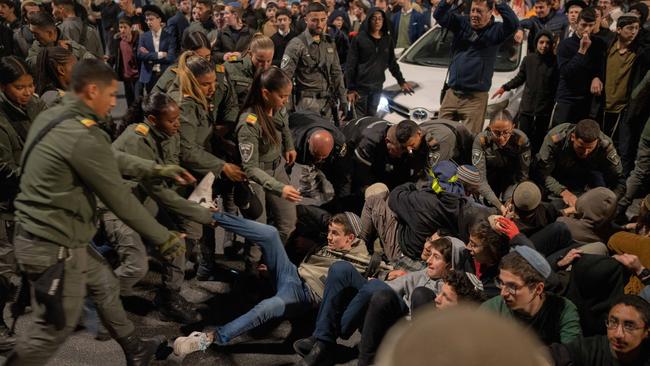 Israeli officers remove activists blocking a road during a protest against the ceasefire deal with Hamas. Picture: Reuters