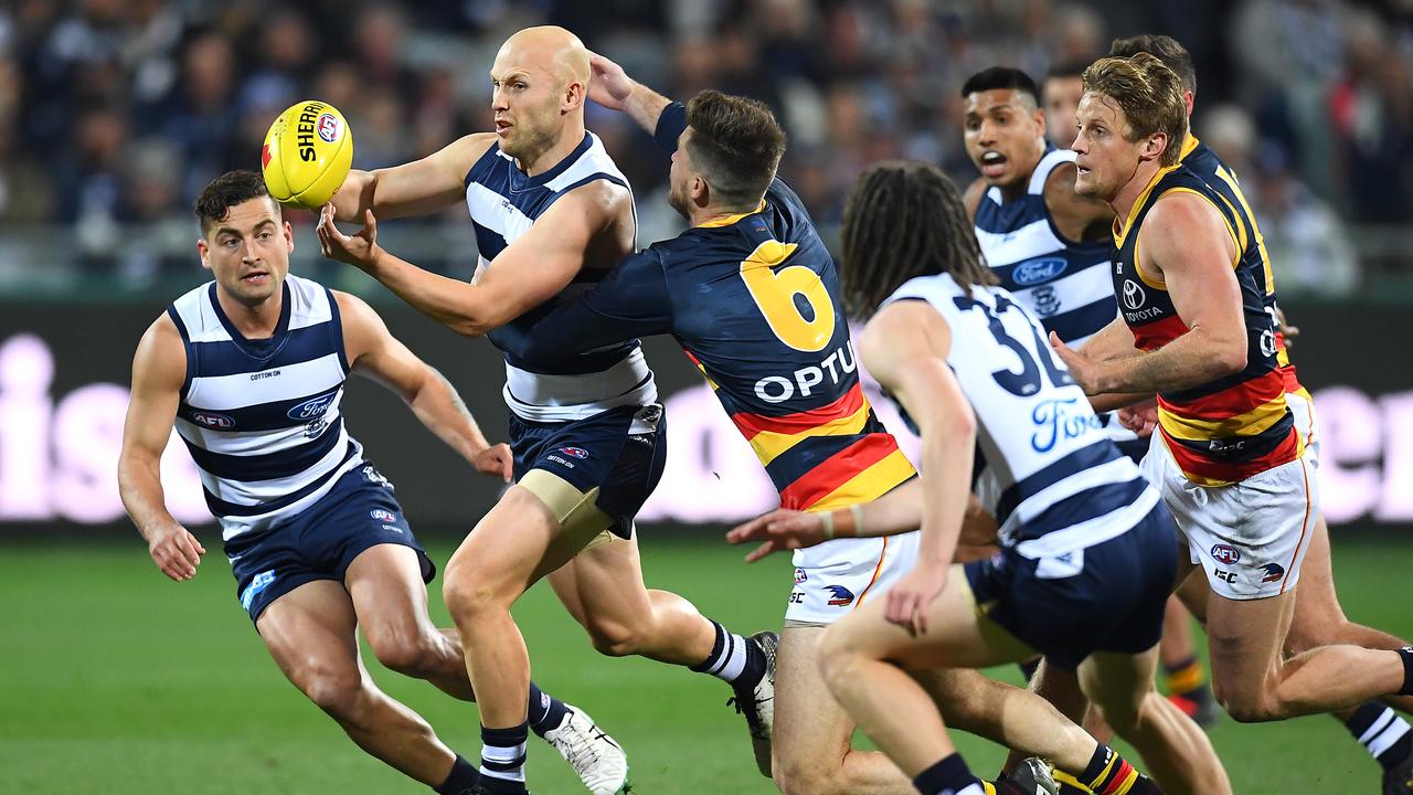 Gary Ablett of the Cats handballs while being tackled by Bryce Gibbs of the Crows. Picture: Getty Images