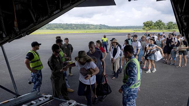 People boarding a Royal Australian Air Force plane after the earthquake struck Port Vila, the capital city of Vanuatu. Overseas rescuers joined a hunt for survivors in the rubble. Picture: DFAT via AFP