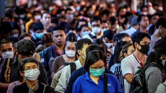 Commuters, wearing facemasks amid fears of the spread of the COVID-19 novel coronavirus, wait for a canal boat in Bangkok. Picture: AFP