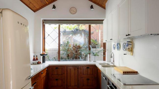The main kitchen is equipped with modern appliances, stone benchtops and a walk-in pantry.