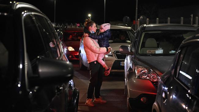 A Ukrainian women holds her child as they wait to enter Romania. Many charities are helping those displaced. Picture: Daniel Mihailescu / AFP