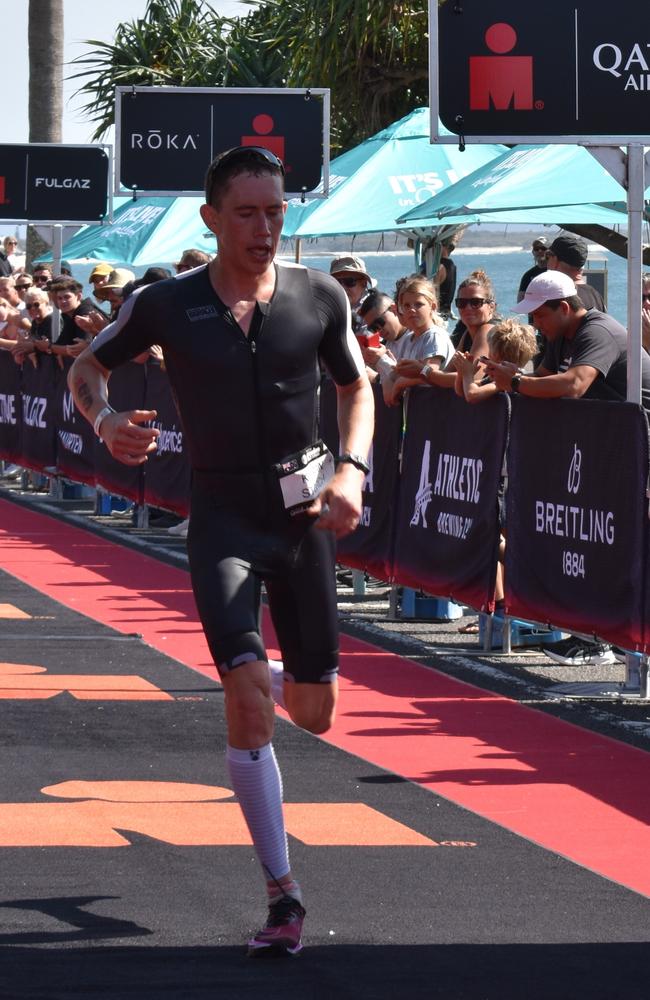 Athletes crossing the finish line at Sunshine Coast Ironman 70.3 2023.