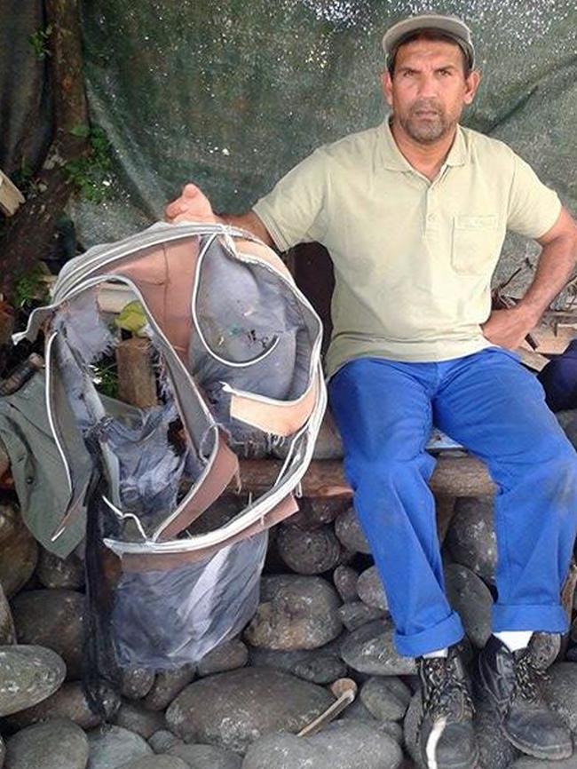 Johnny Begue, a member of a local shore cleaning association, on Reunion Island with the bag that has been linked to a female passenger from MH370. Picture: AFP