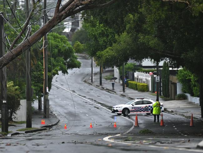 BRISBANE, AUSTRALIA - MARCH 08: A fallen tree blocks traffic on Wynnum Road in the suburb of Norman Park on March 08, 2025 in Brisbane, Australia. Australia's east coast, particularly Queensland and northern New South Wales, is bracing for the impact of Tropical Cyclone Alfred, a Category 2 storm expected to make landfall between Noosa and Coolangatta, near Brisbane, late Friday or early Saturday. The cyclone is anticipated to bring damaging winds, life-threatening flooding, and coastal erosion, with thousands ordered to evacuate and tens of thousands experiencing power outages. Authorities have issued severe weather warnings, closed airports and schools, and deployed emergency services to assist with rescue and relief operations as the storm's slow movement extends its impact on coastal areas. (Photo by Albert Perez/Getty Images)