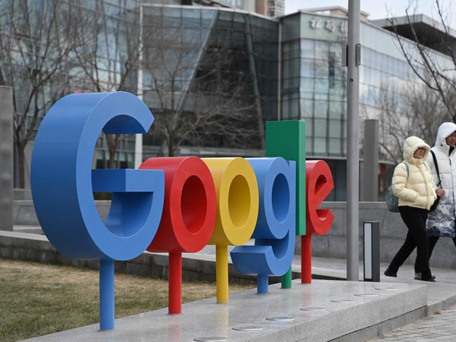 People walk past a Google logo outside a building housing Google offices in Beijing on February 4, 2025. China on February 4 said it would probe US tech giant Google over violations of anti-monopoly laws after Washington slapped 10 percent levies on Chinese goods. (Photo by GREG BAKER / AFP)