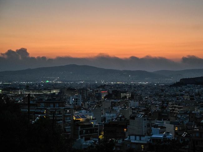 An aerial view of Athens shows smoke from a fire in the background as Europe wilted under a relentless heatwave and wildfires. Picture: AFP