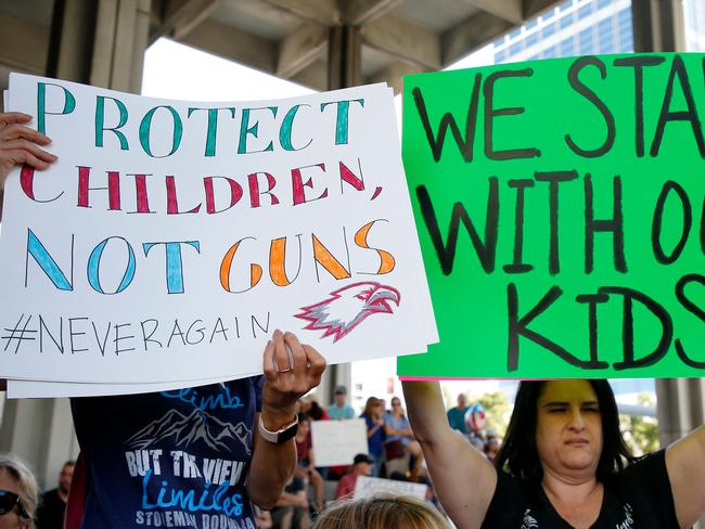 Protesters hold signs at a rally for gun control after 17 perished and more than a dozen were wounded in the hail of bullets at Marjory Stoneman Douglas High School in Florida. Picture: AFP