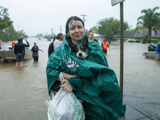 A woman and her dog are helped to safety. Picture: Media Mode