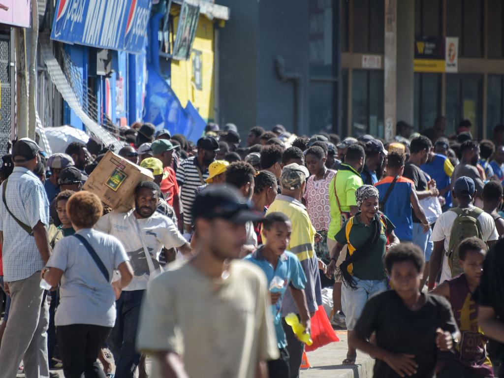 People surround stores amid a state of unrest in Port Moresby. Picture: AFP