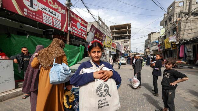 A girl carries a canvas bag filled with food aid bearing the logo of non-profit non-governmental organisation World Central Kitchen on March 17. Picture: AFP