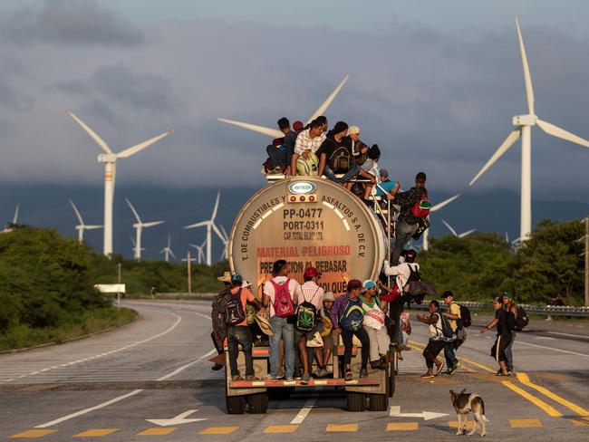 TOPSHOT - A truck carrying mostly Honduran migrants taking part in a caravan heading to the US, passes by a wind farm on their way from Santiago Niltepec to Juchitan, near the town of La Blanca in Oaxaca State, Mexico, on October 30, 2018. - The Pentagon is deploying 5,200 active-duty troops to beef up security along the US-Mexico border, officials announced Monday, in a bid to prevent a caravan of Central American migrants from illegally crossing the frontier. (Photo by GUILLERMO ARIAS / AFP)