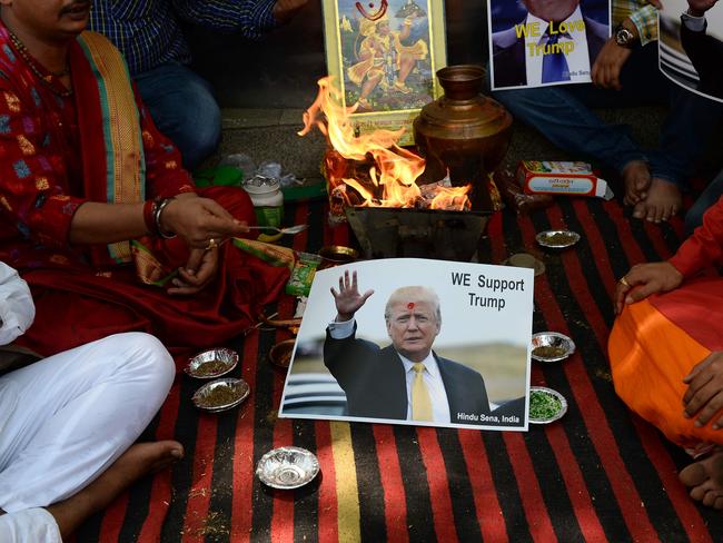 An Indian Hindu priest performs a Hawan (The Sarced Fire) ritual alongside posters bearing the image of US Republican presidential candidate Donald Trump in New Delhi.  Picture:  AFP