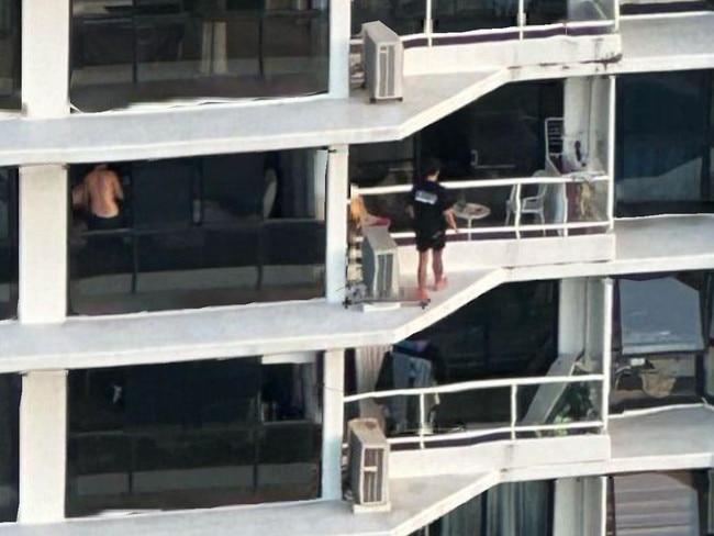 A picture has gone viral of a man ‘balcony hopping’ several metres above ground, prompting authorities to warn others from participating in the risky activity. Picture: Facebook