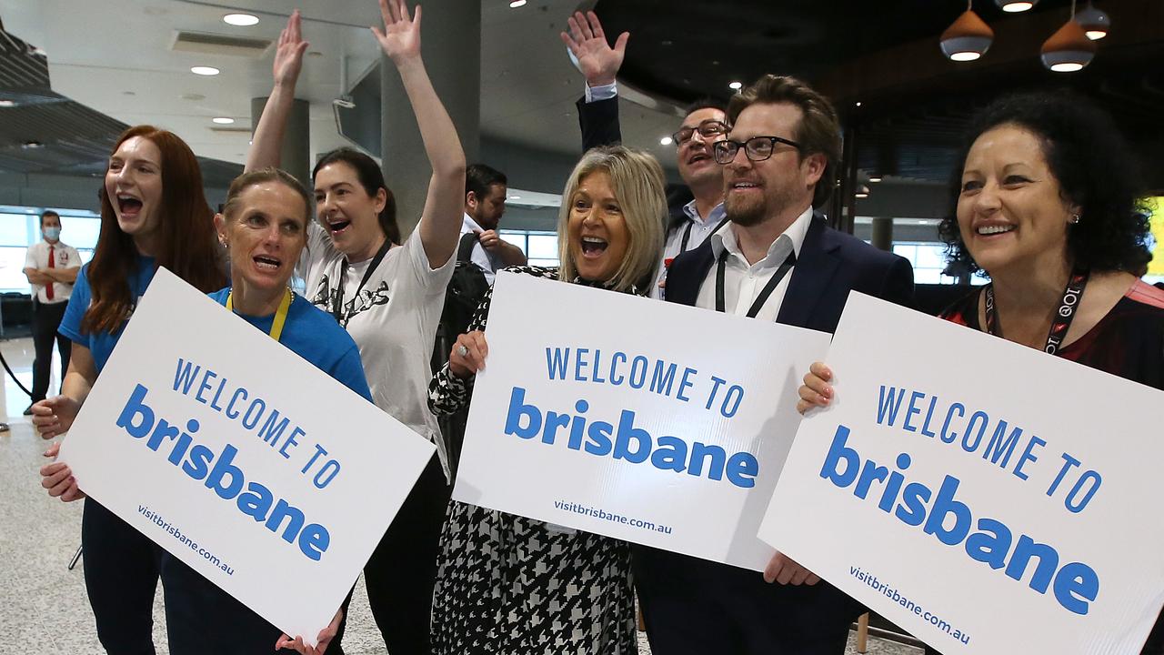 Airport staff greet the first passengers back from Sydney since the Queensland borders reopened. Picture: Jono Searle/Getty Images