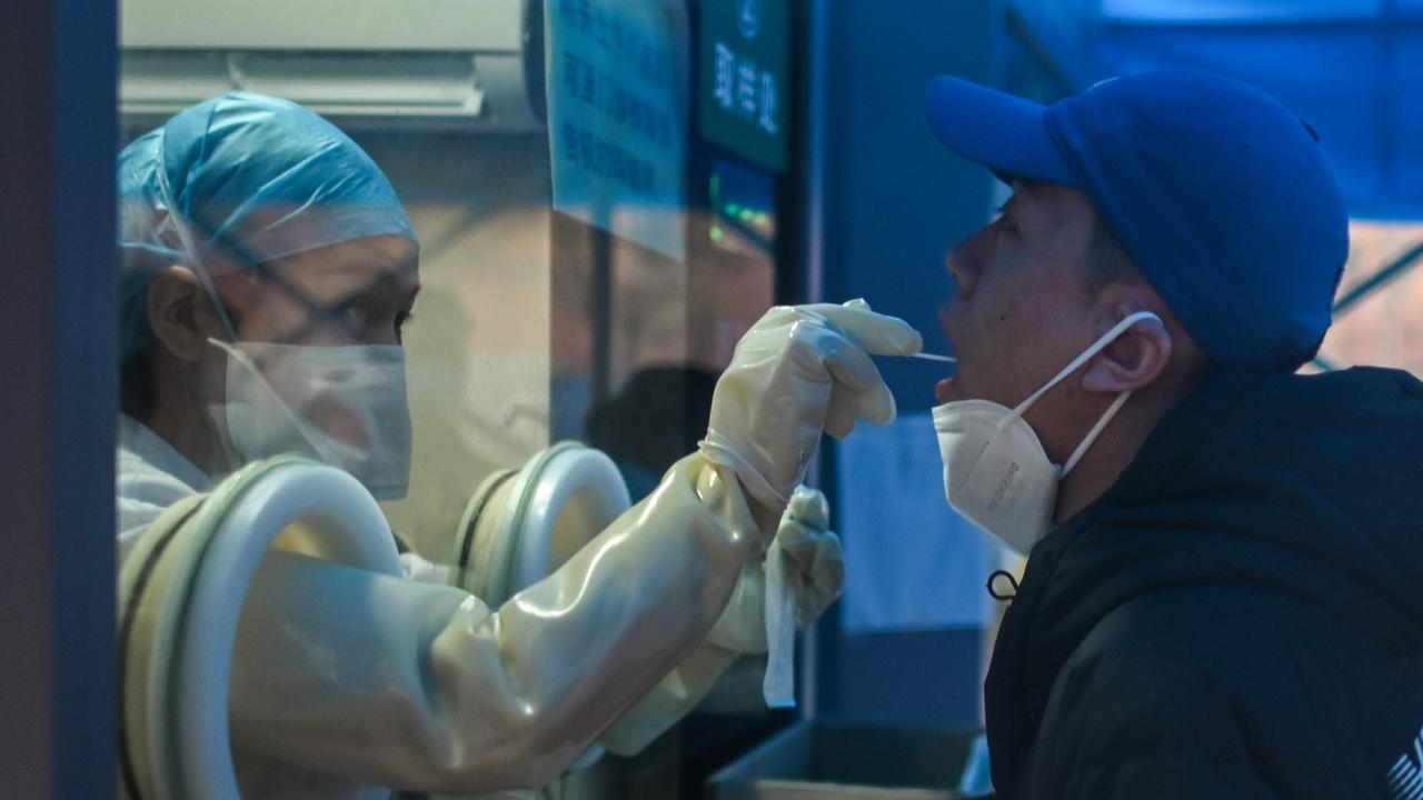 A health worker takes a swab sample to test for Covid-19 at a hospital in Wuhan. Picture: Hector Retamal/AFP