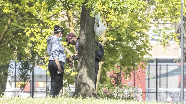 People loitering in a park near the injecting room. Picture: Jake Nowakowski