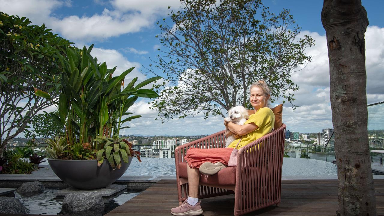 Cathy Purbrick with her dog Lucy enjoy the tree lined rooftop of her apartment building. Picture: Brad Fleet