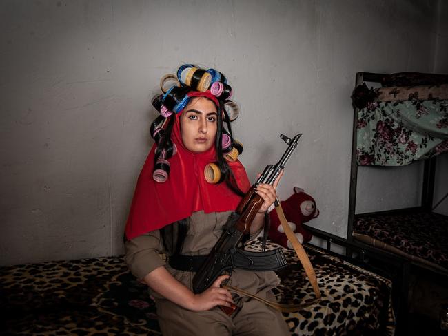 A young Iranian Kurdish soldier sits in her dormitory with her hair flowing out of her veil, appearing wild and messy, mirroring her right to freedom of expression. Picture: Silvia Alessi